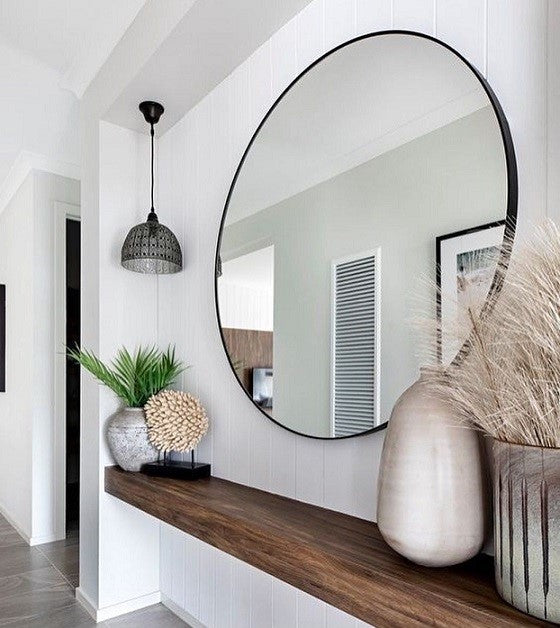 מראה עגולה מעוצבת עם מסגרת שחורה בעיצוב מינימליסטי