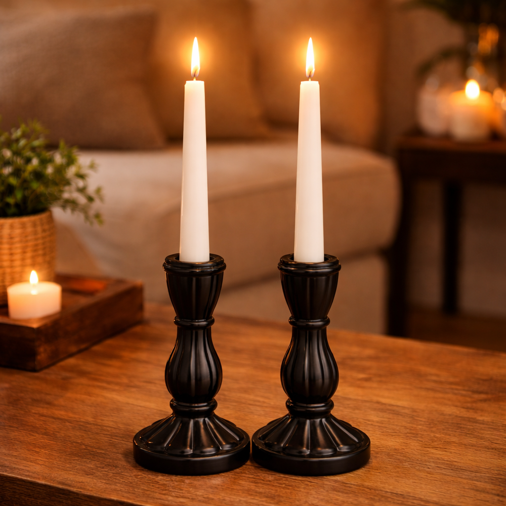 פמוטי קרמיקה שחורים עם נרות לבנים על שולחן עץ בעיצוב סלון חמים